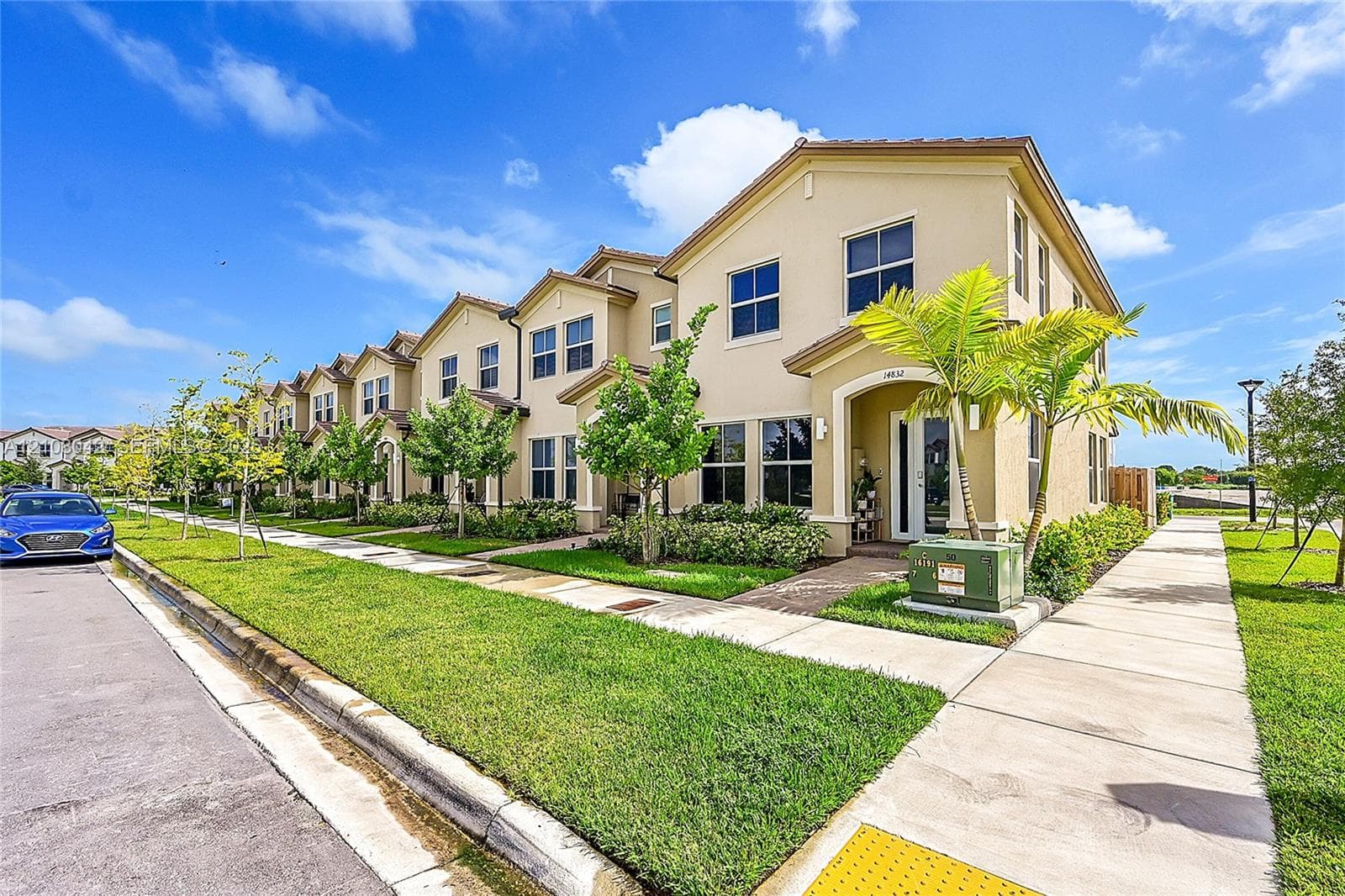 Stucco exterior featuring multi-gabled rooflines, rectangular windows, and a paved walkway