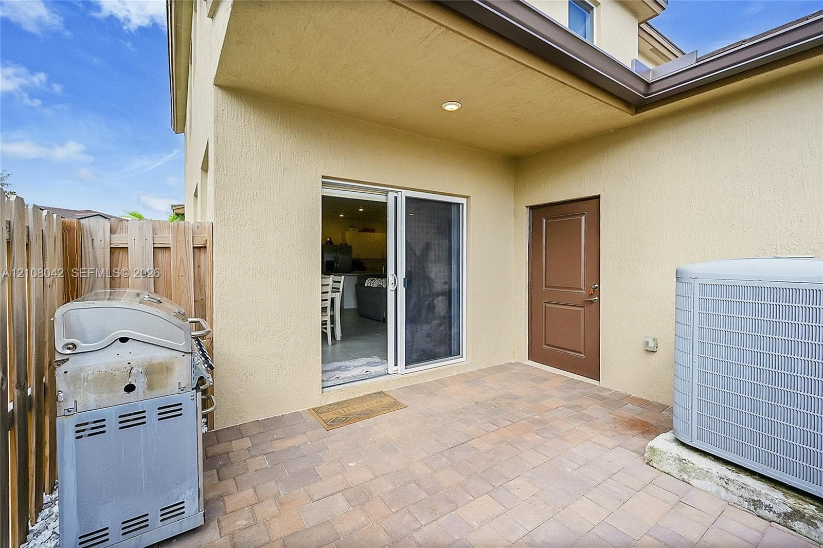 Covered patio featuring paver flooring, recessed lighting, and a solid-core exterior door