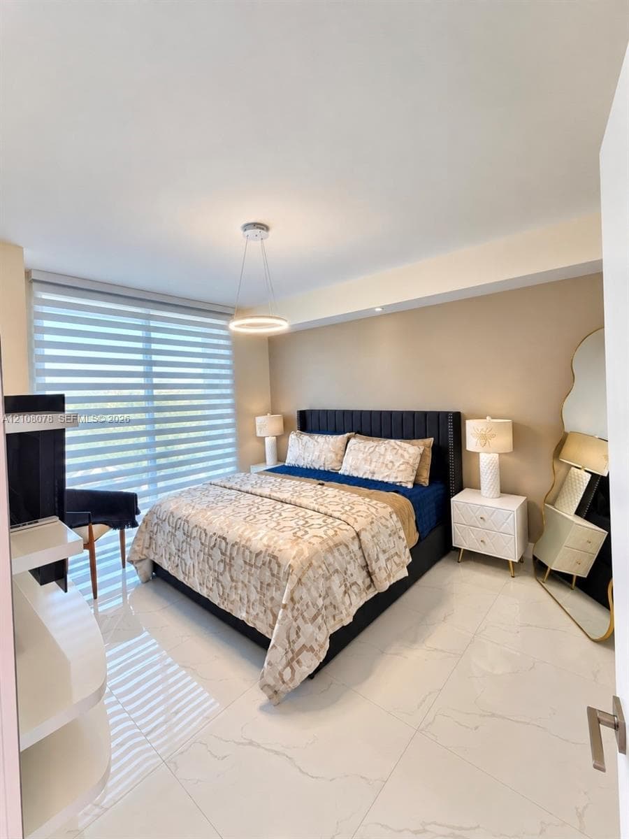 Large-format tile flooring, oversized window with adjustable roller shades, modern circular pendant lighting, and built-in white shelving