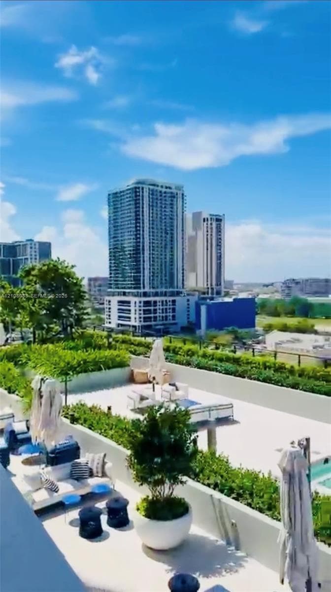 Elevated rooftop terrace featuring a paved surface, perimeter hedges, and an integrated swimming pool