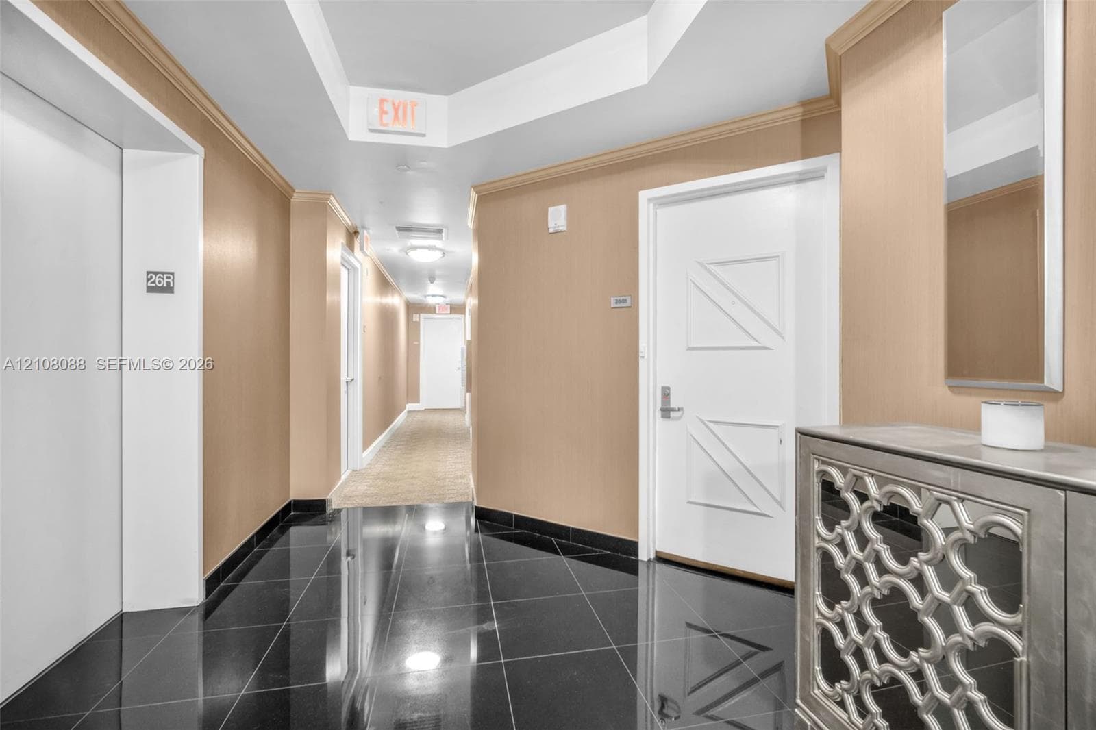 Semi Private Foyer Polished black tile flooring, beige wall surfacing, recessed tray ceiling, and white paneled doors