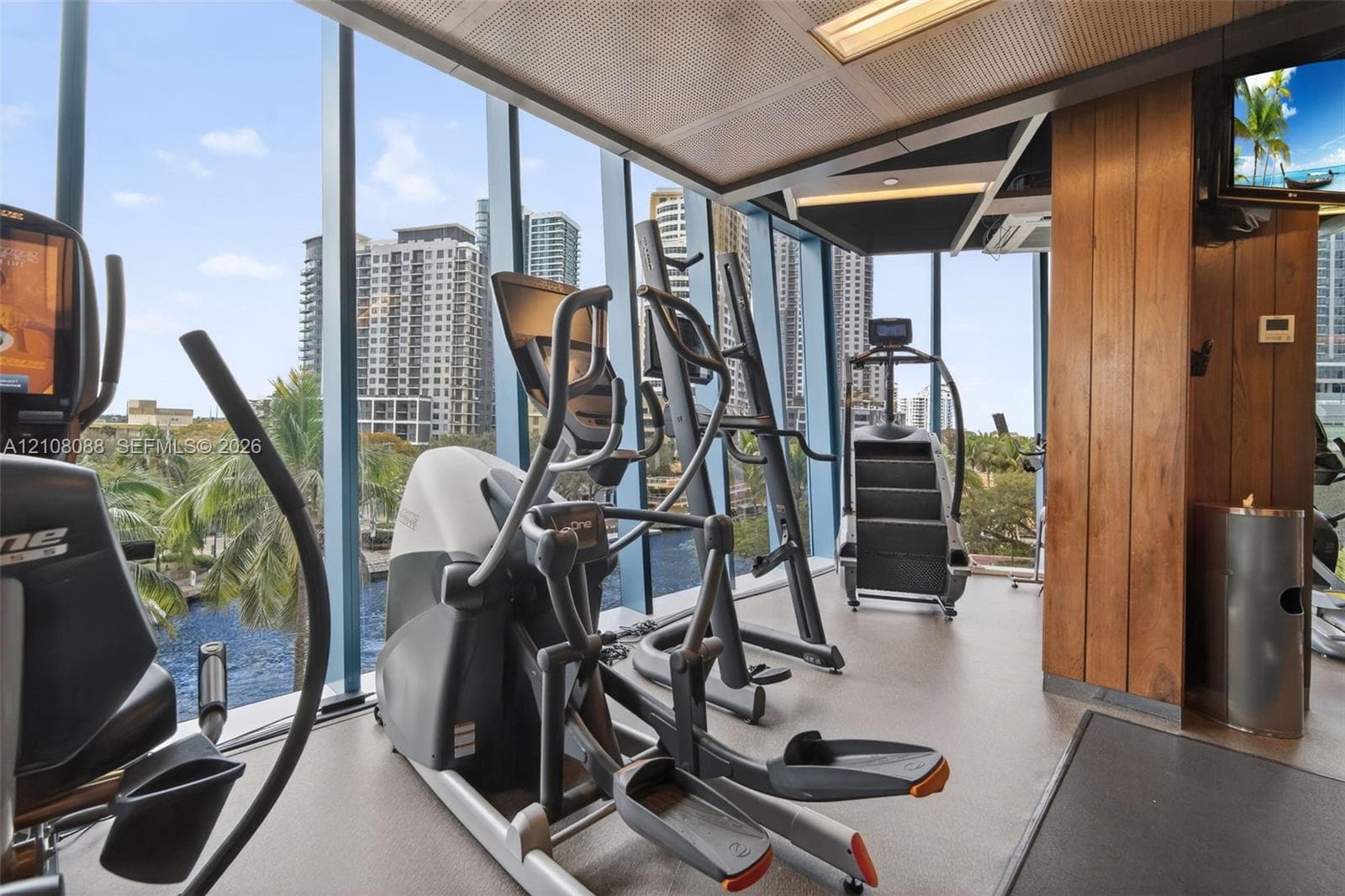 Floor-to-ceiling windows, wood-finish paneling, and metal grid ceiling tiles