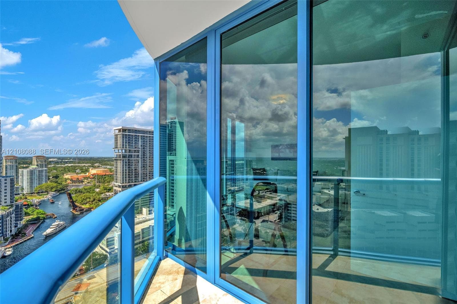 Private balcony featuring floor-to-ceiling glass paneling, metal railings, and stone-tile flooring