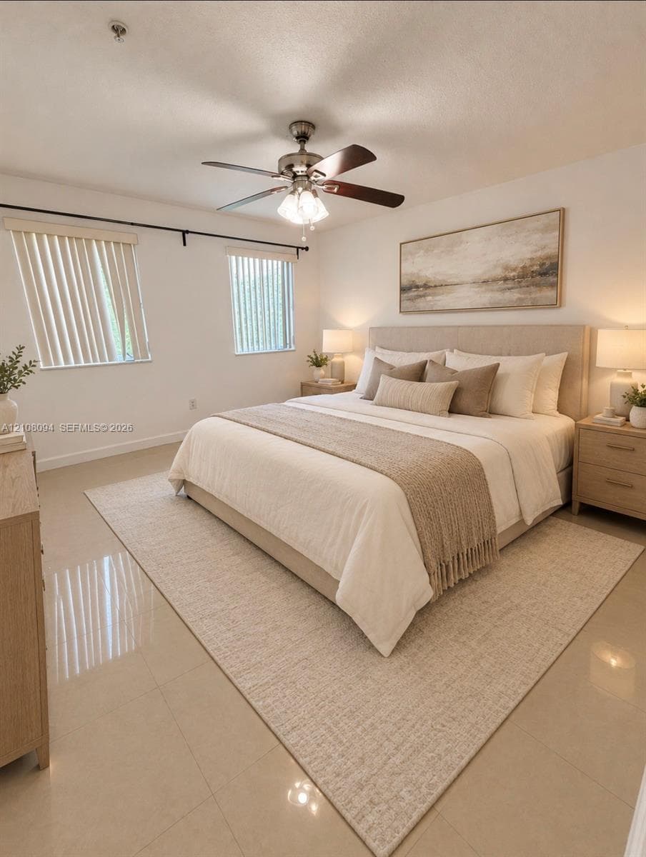 Neutral tile flooring, ceiling fan with light fixture, and dual windows with fitted vertical blinds