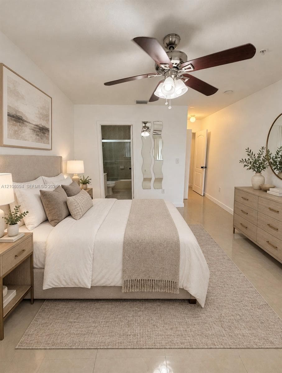 Neutral-toned interior featuring polished tile flooring, a multi-blade ceiling fan with integrated light fixture, and an en-suite bathroom with a glass-enclosed shower