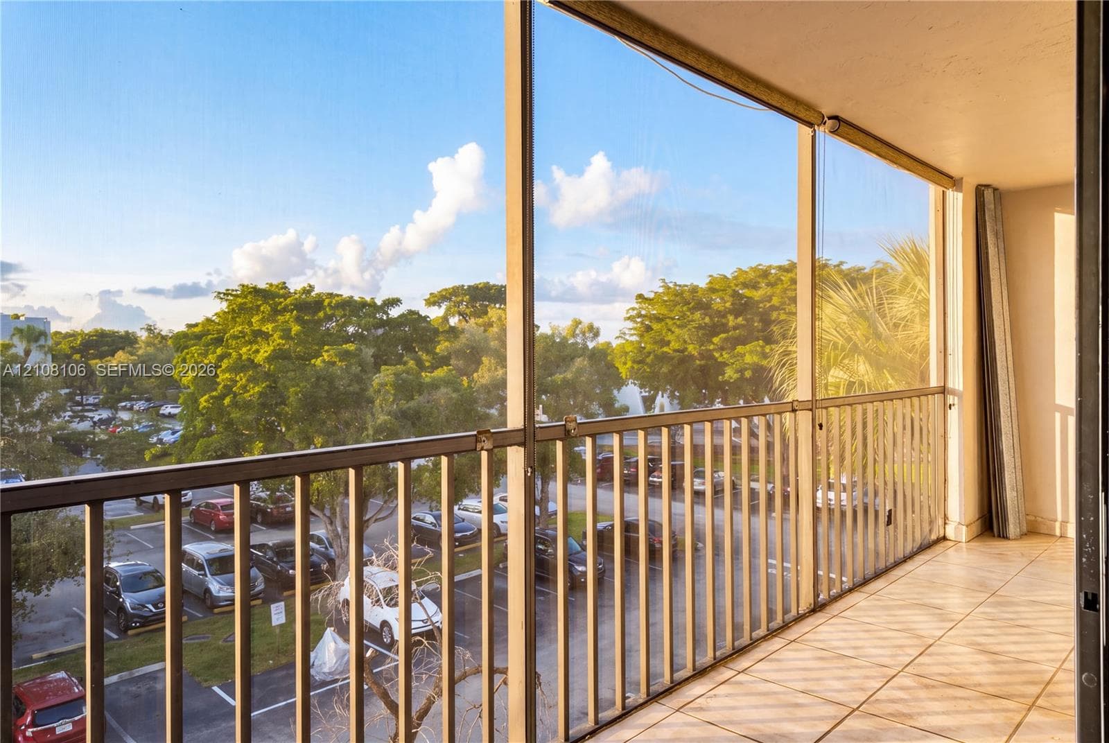 Screened-in balcony featuring ceramic tile flooring and metal railings