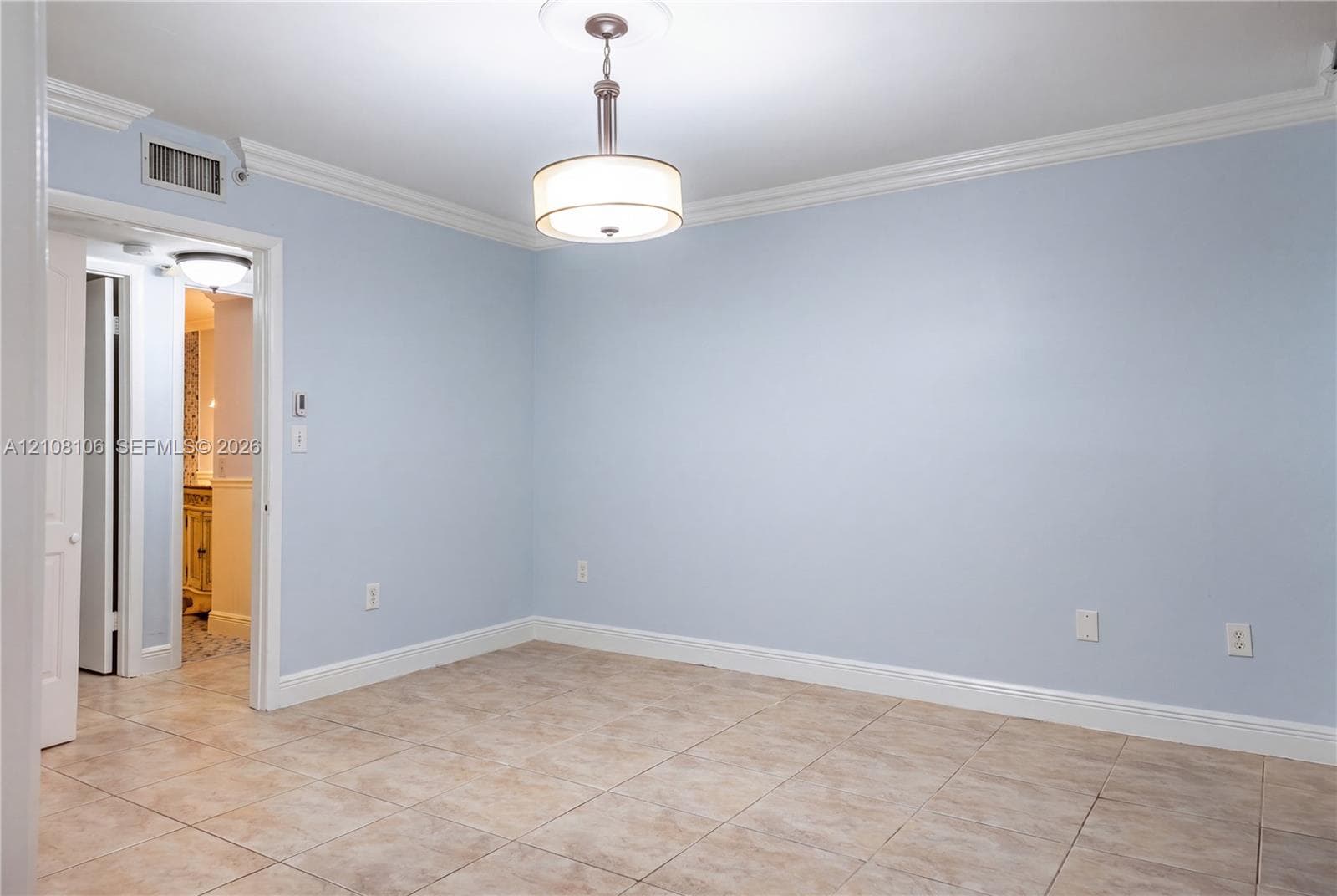 Neutral-toned ceramic tile flooring, crown molding, and a drum-style pendant light fixture