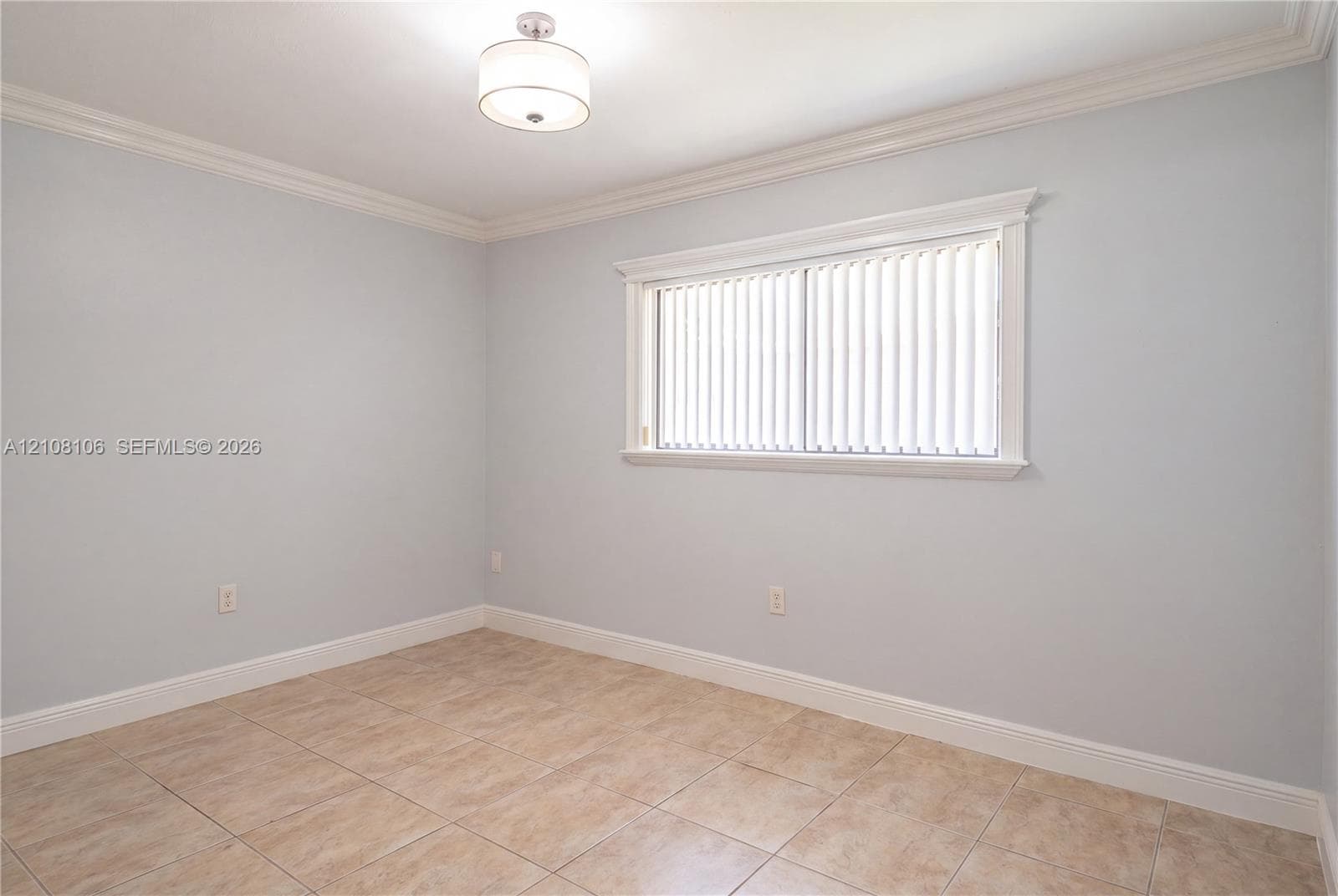 Ceramic tile flooring, crown molding, and a drum-style ceiling light fixture