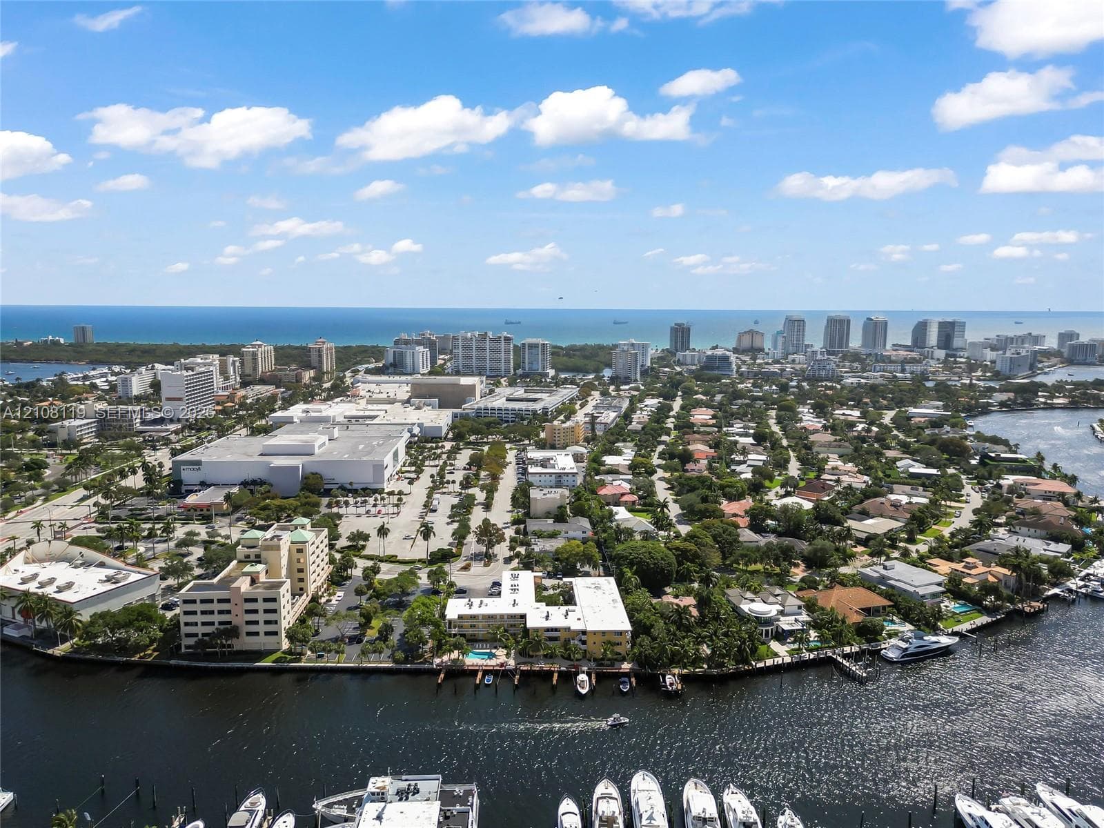 Aerial perspective featuring coastal proximity, deep-water canal access, private boat slips, and dense canopy of mature trees
