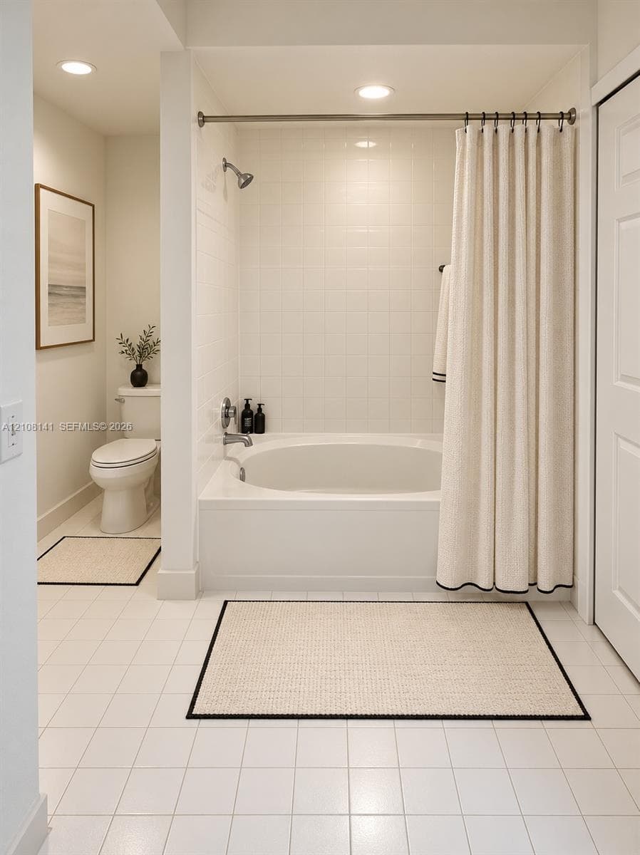 Bathroom featuring a built-in soaking tub with a tiled surround, recessed lighting, and white tile flooring