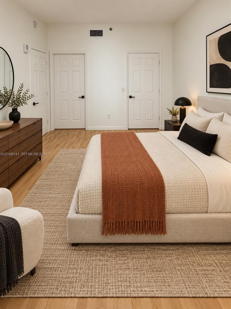 Wood-finish flooring, two six-panel interior doors with matte black hardware, and crisp neutral wall finish