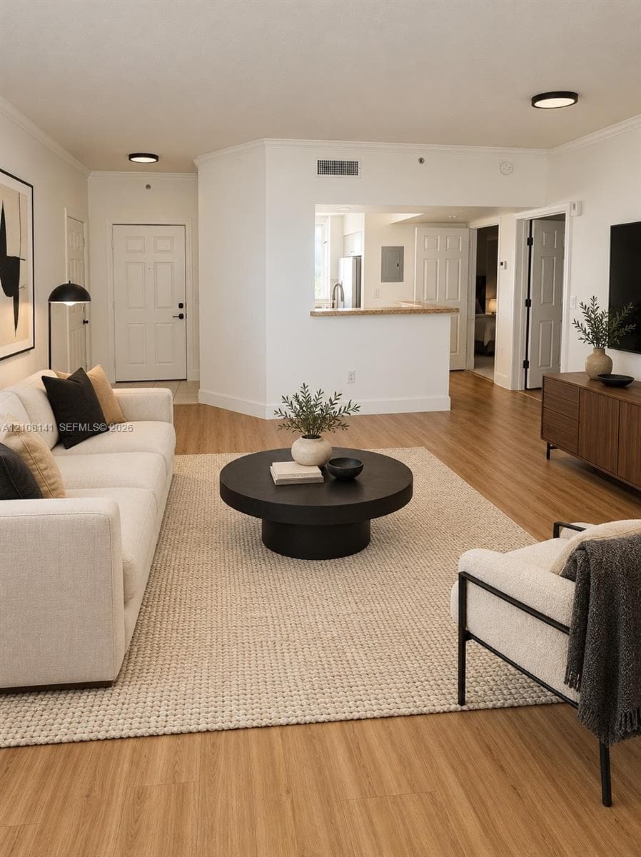 Living area featuring wood-finish flooring, recessed ceiling lighting, and a kitchen pass-through with a solid surface countertop