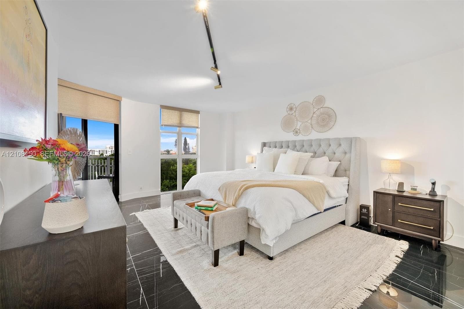 Spacious room featuring polished stone flooring, floor-to-ceiling windows, roller shades, and adjustable track lighting