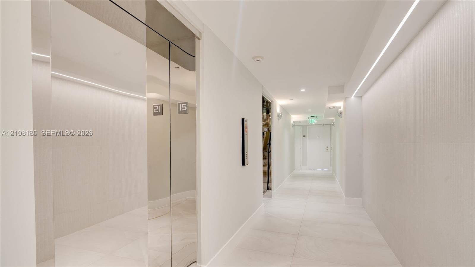 Polished chrome elevator doors, textured wall cladding, large-format tile flooring, and integrated linear LED ceiling lighting