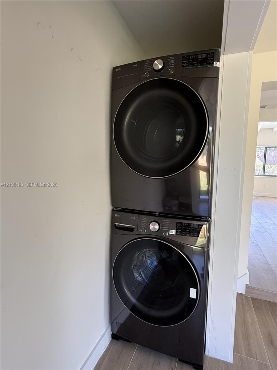 Stacked metallic-finish front-load laundry unit featuring integrated digital control panels