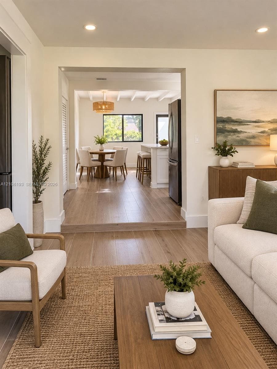 Wood-finish flooring, recessed lighting, and kitchen island with white cabinetry