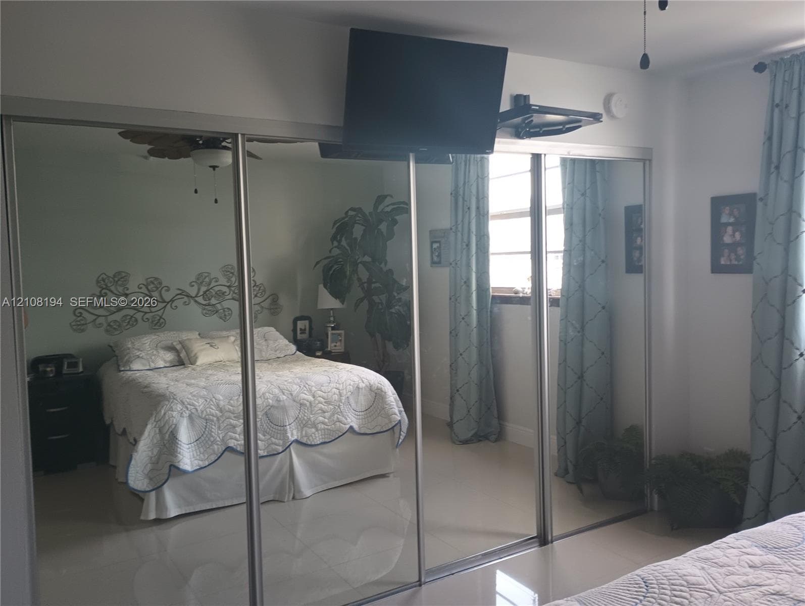 Floor-to-ceiling mirrored closet doors with brushed metal frames and polished tile flooring