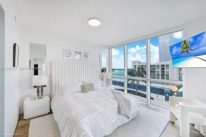 Floor-to-ceiling windows, wood-finish flooring, and recessed ceiling lighting