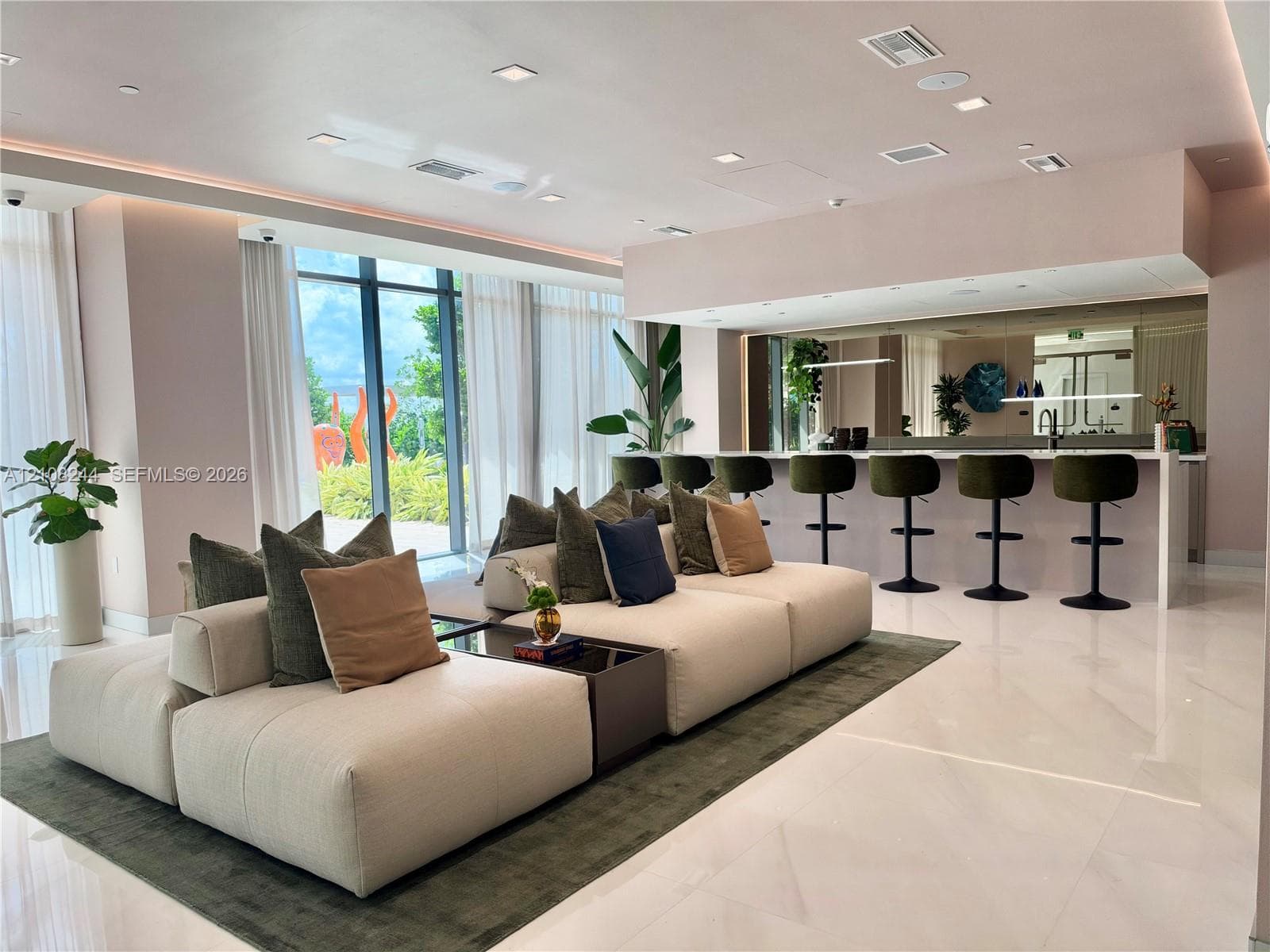 Common area featuring floor-to-ceiling windows, polished tile flooring, recessed ceiling lighting, and a built-in bar with mirror backsplash