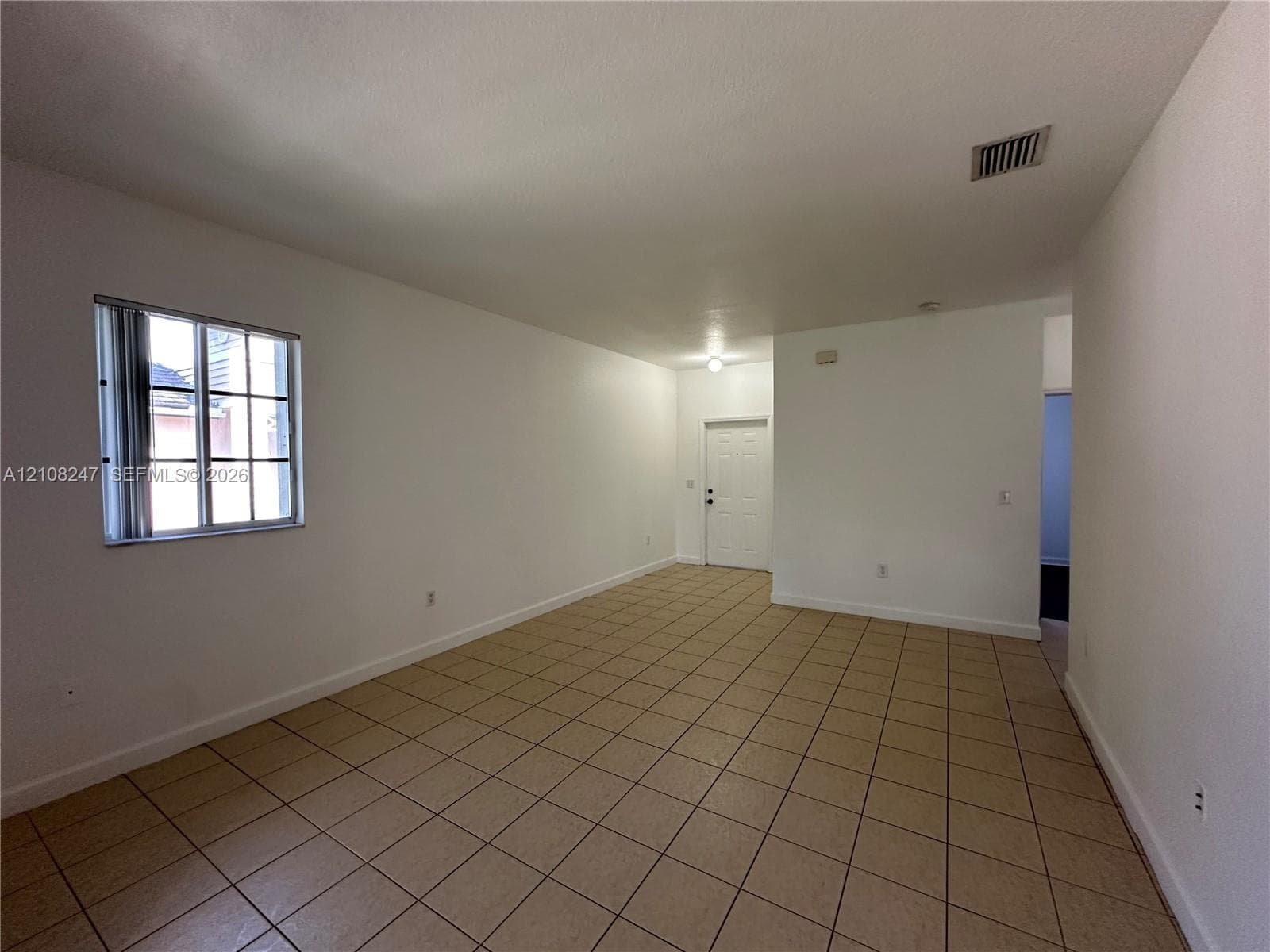 Interior area featuring tile flooring, neutral wall paint, and a grid-pane window