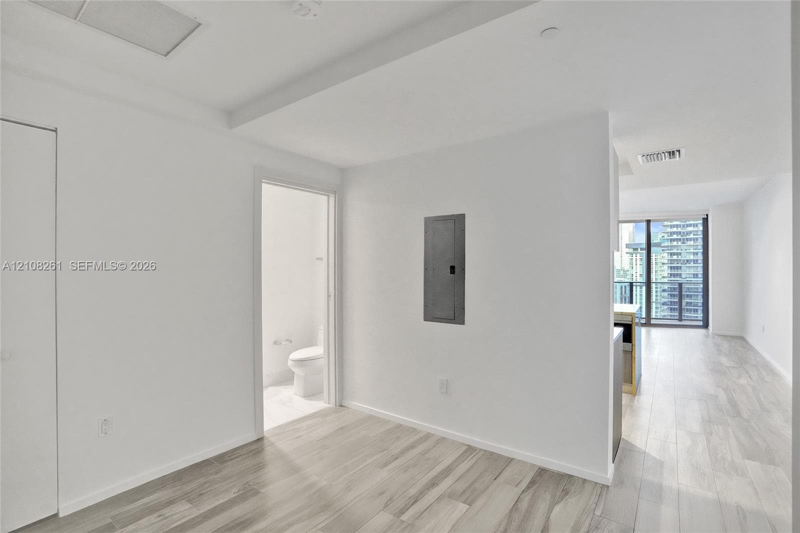 Neutral interior featuring wood-finish flooring, floor-to-ceiling window wall, and recessed ceiling lighting