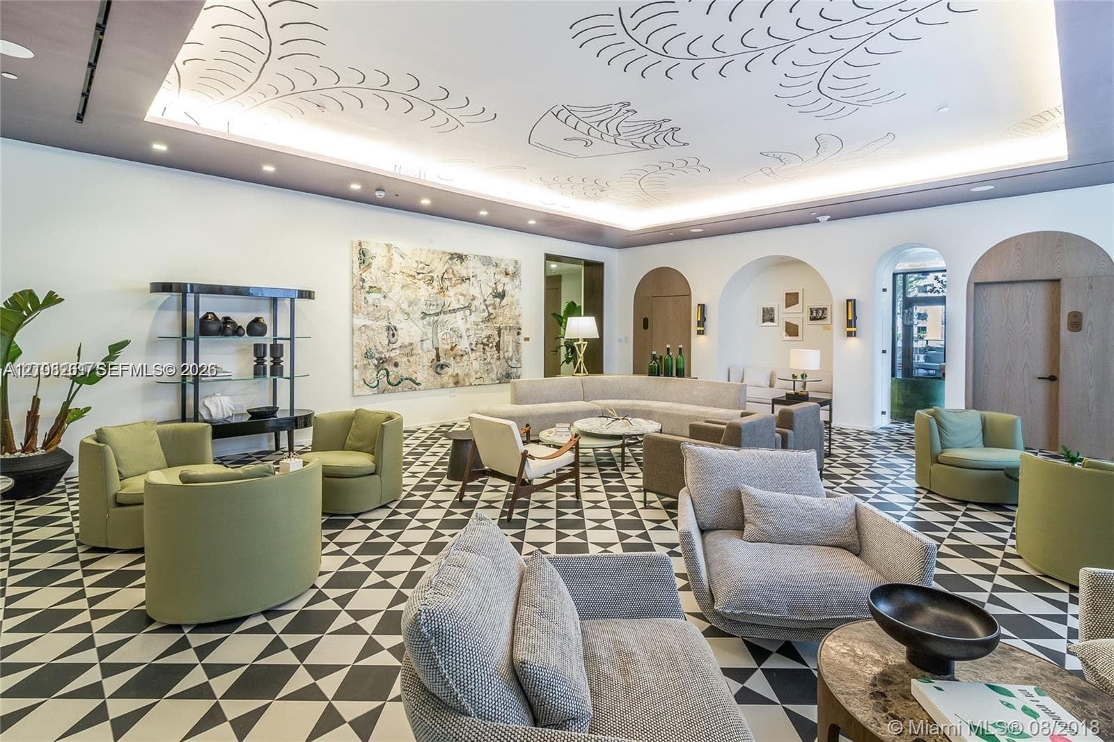 Geometric tile flooring, tray ceiling with custom illustration and recessed cove lighting, and arched doorways featuring wood-finish doors