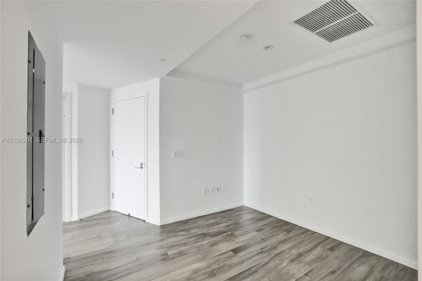 Interior space featuring neutral wall tones, wood-finish flooring, and a solid-core interior door