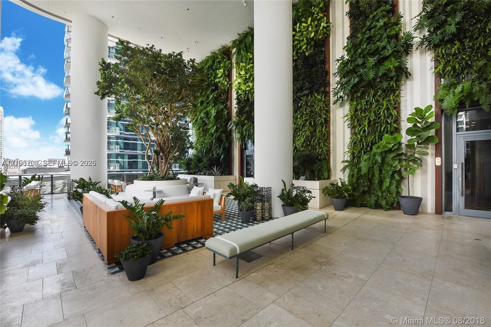 Covered terrace featuring large-scale stone flooring, multi-story vertical gardens, and prominent structural pillars