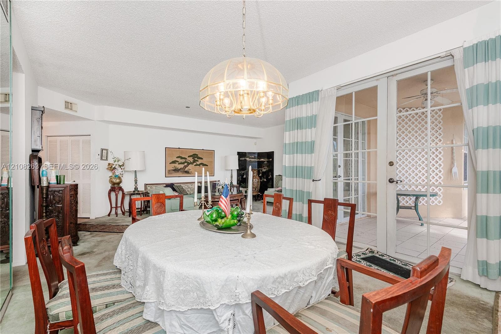 Dining space featuring a multi-tiered glass dome chandelier and glass-paned sliding doors opening to an exterior patio