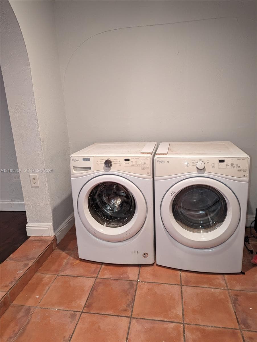 Laundry area featuring ceramic tile flooring and an arched architectural opening