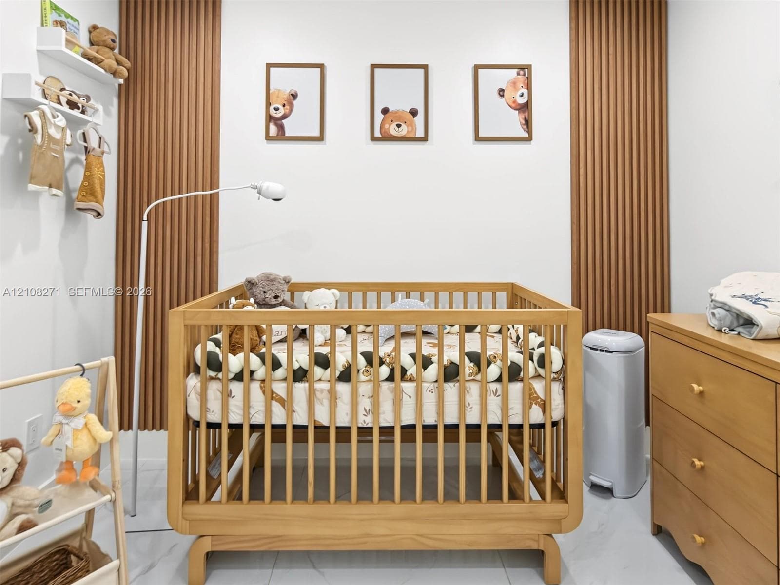 Wall-mounted white shelving, vertical wood-slat accent paneling, and large-format tile flooring