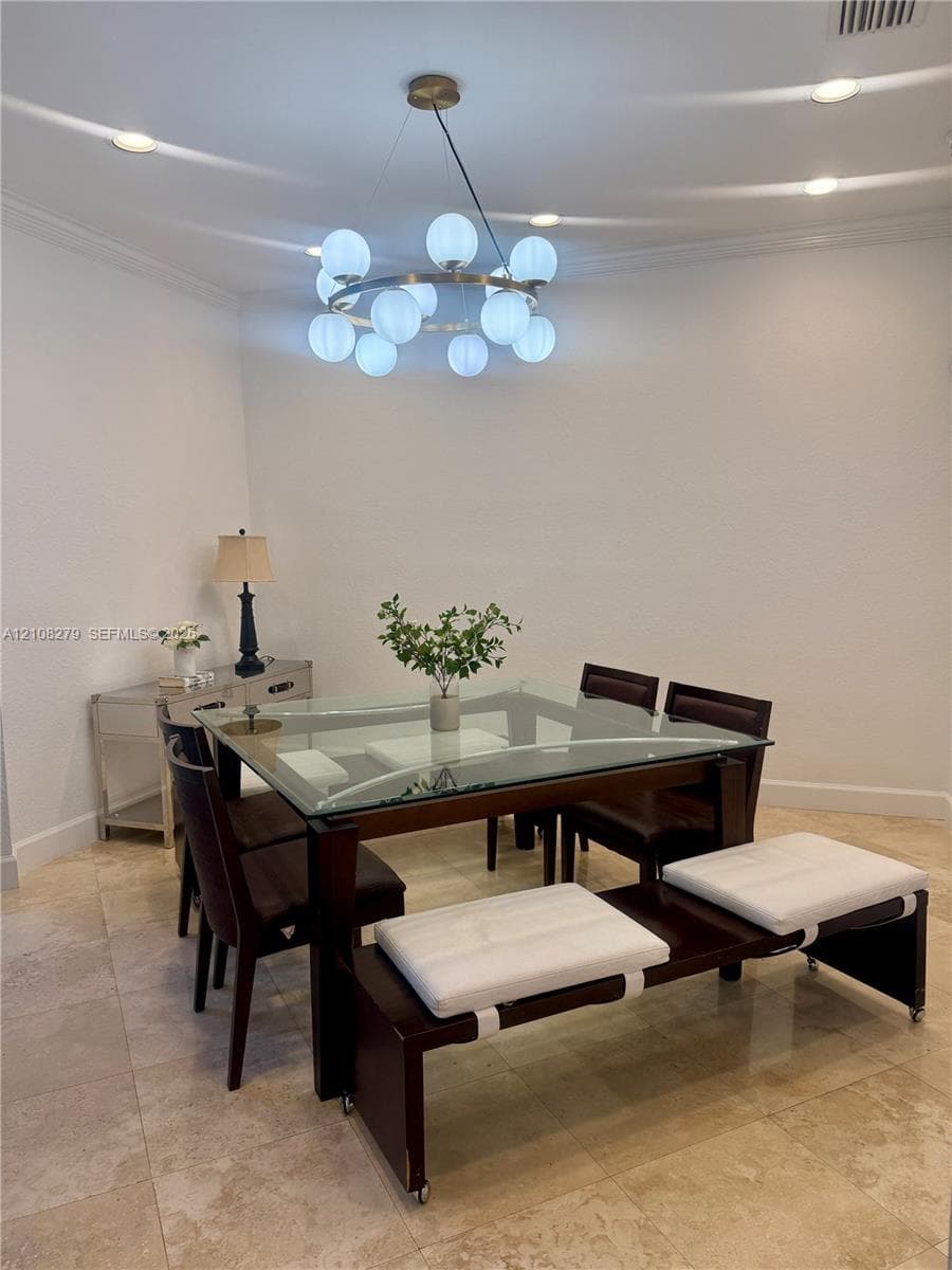 Circular multi-light chandelier, recessed lighting, and stone flooring