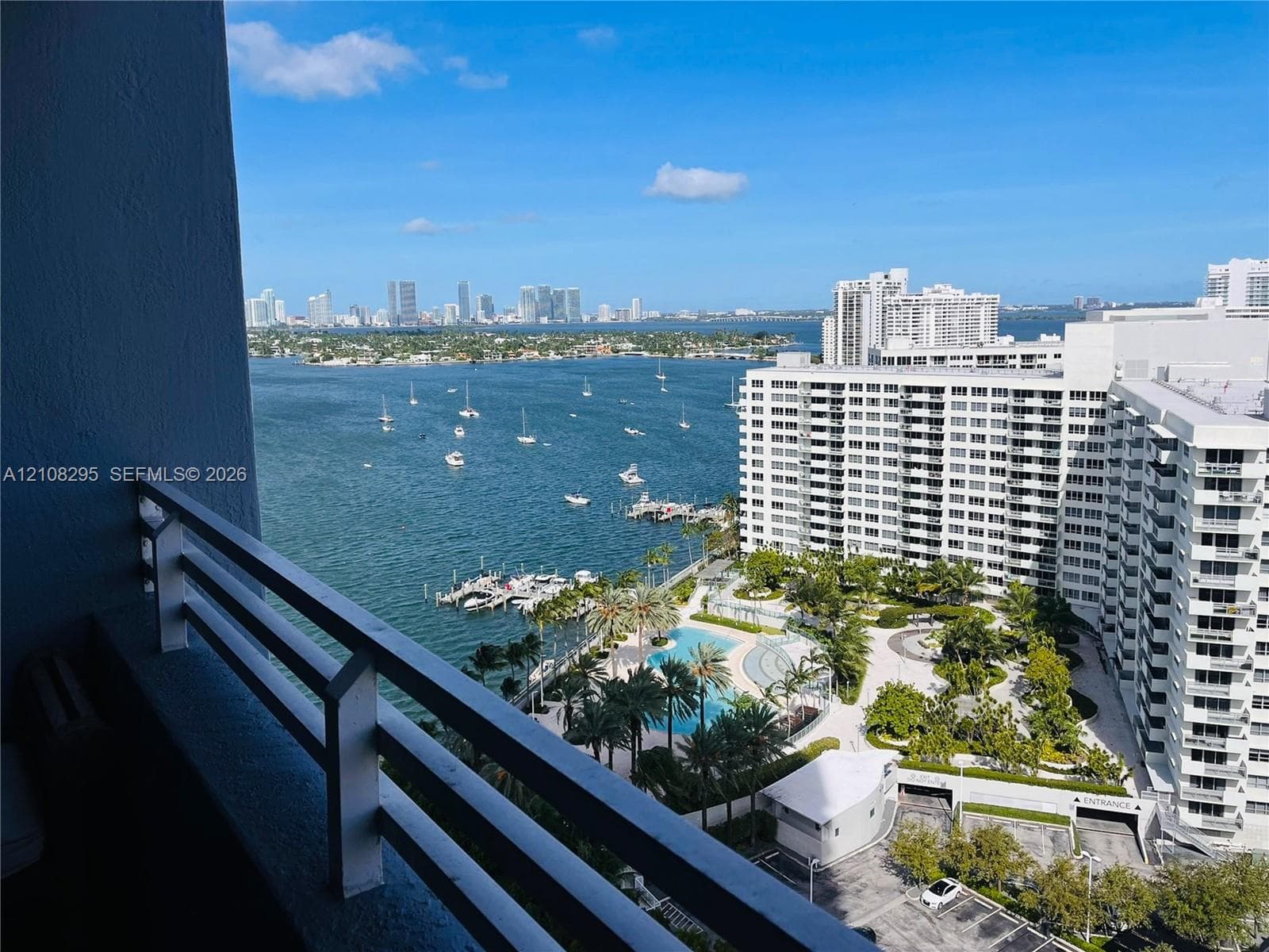 Private balcony featuring a metal railing with a wide-angle perspective of the waterfront, marina, and city skyline