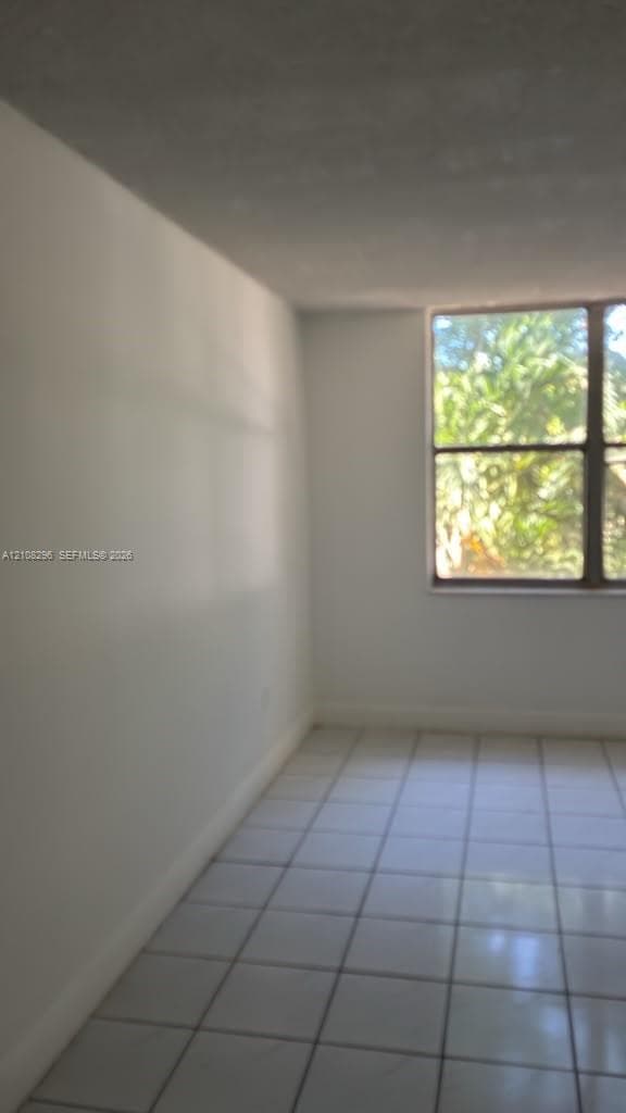 Interior space featuring large-format tile flooring and a multi-pane window
