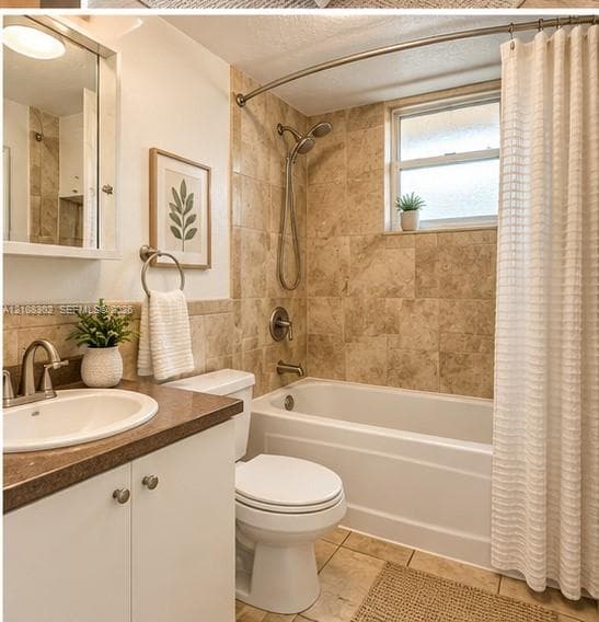 Bathroom featuring a white vanity cabinet, solid-surface countertop with an integrated basin, tile-surround bathtub with a handheld shower fixture, and tiled flooring
