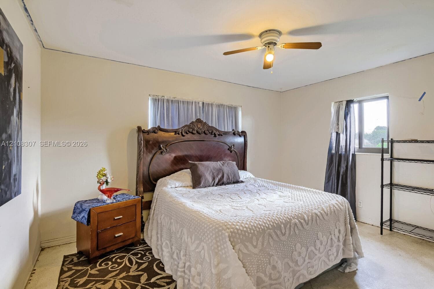 Room featuring neutral-toned walls, a central ceiling fan with integrated lighting, and natural light provided by a dual-pane window