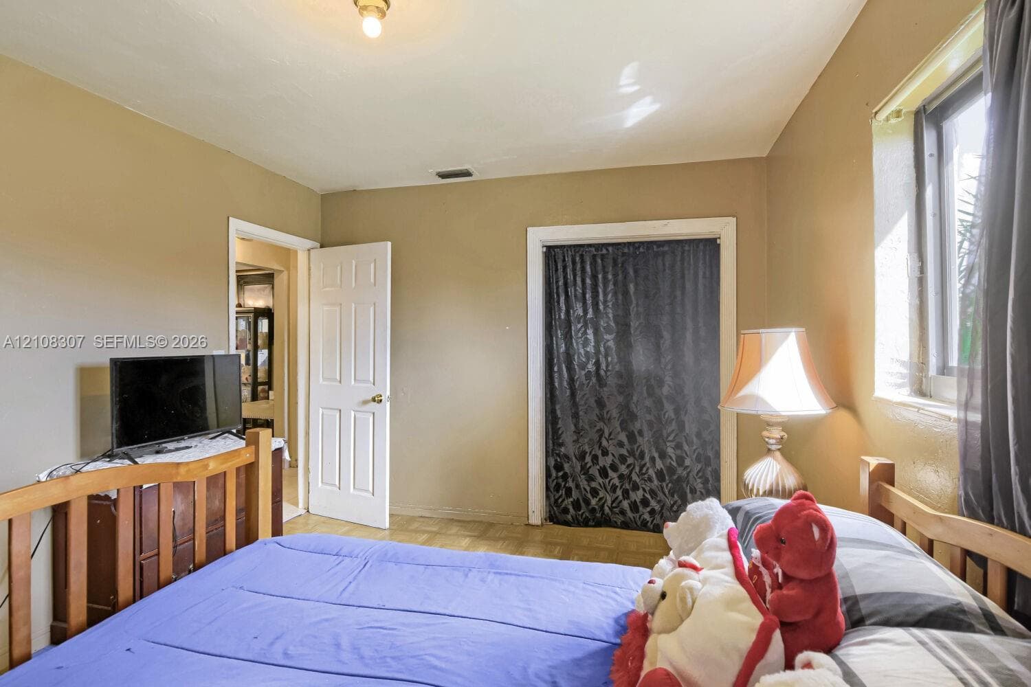 Room featuring a flush-mount ceiling light, single-panel interior door, and window with casing