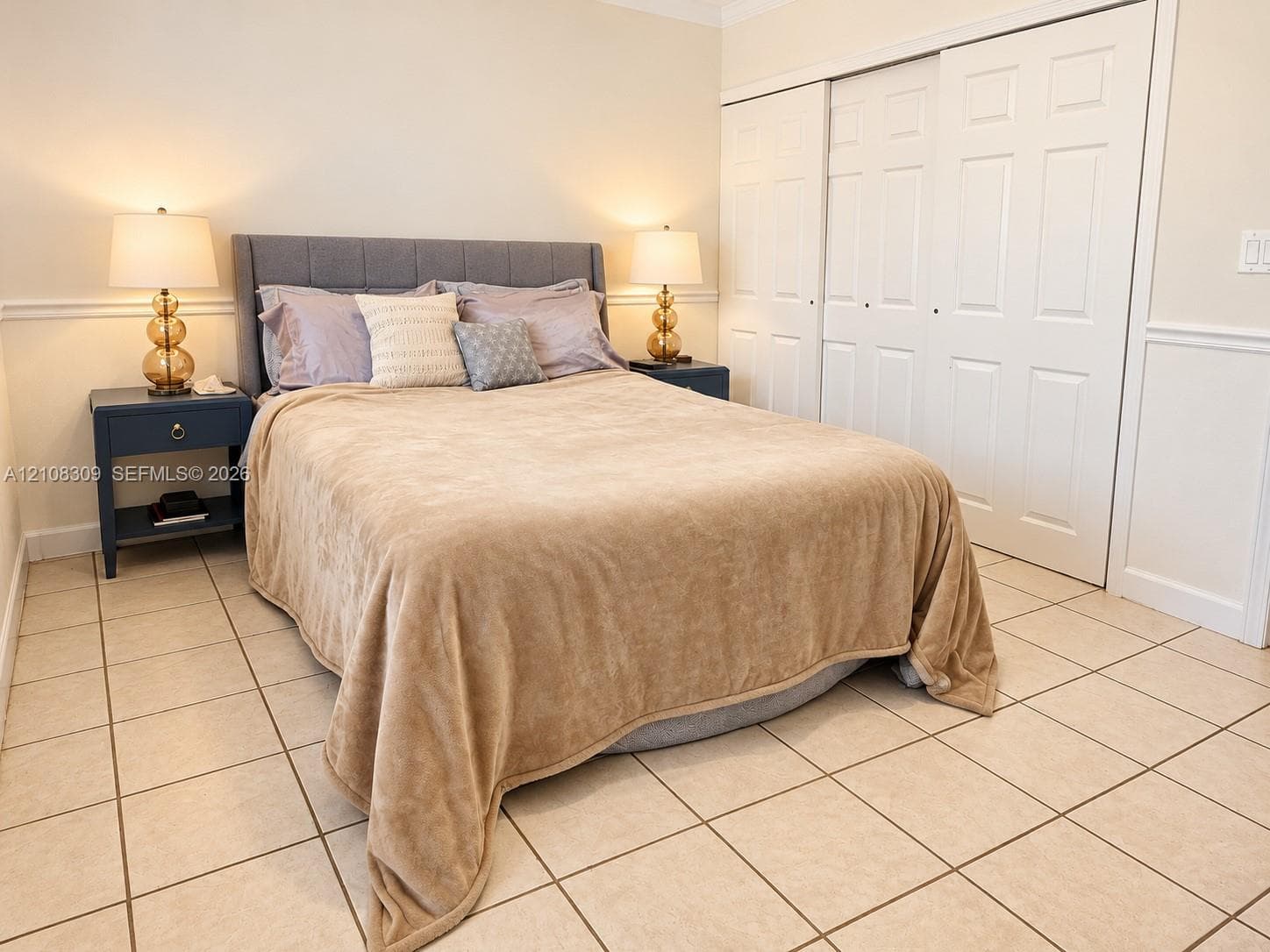Ceramic tile flooring, white six-panel sliding closet doors, and chair rail molding