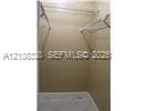 Walk-in closet featuring dual-level wire shelving and wood-finish flooring