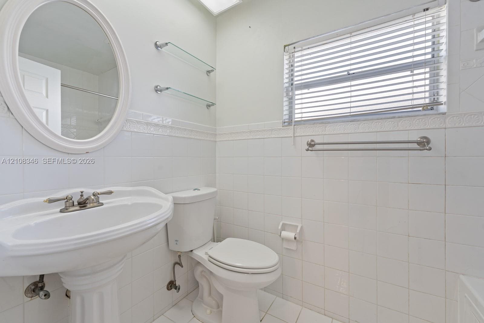 Utility space featuring white wall-mounted cabinetry, tile flooring, and a six-panel exterior door