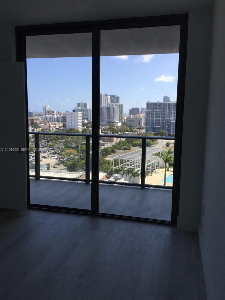 Floor-to-ceiling glass panel windows with metal framing and wood-finish flooring