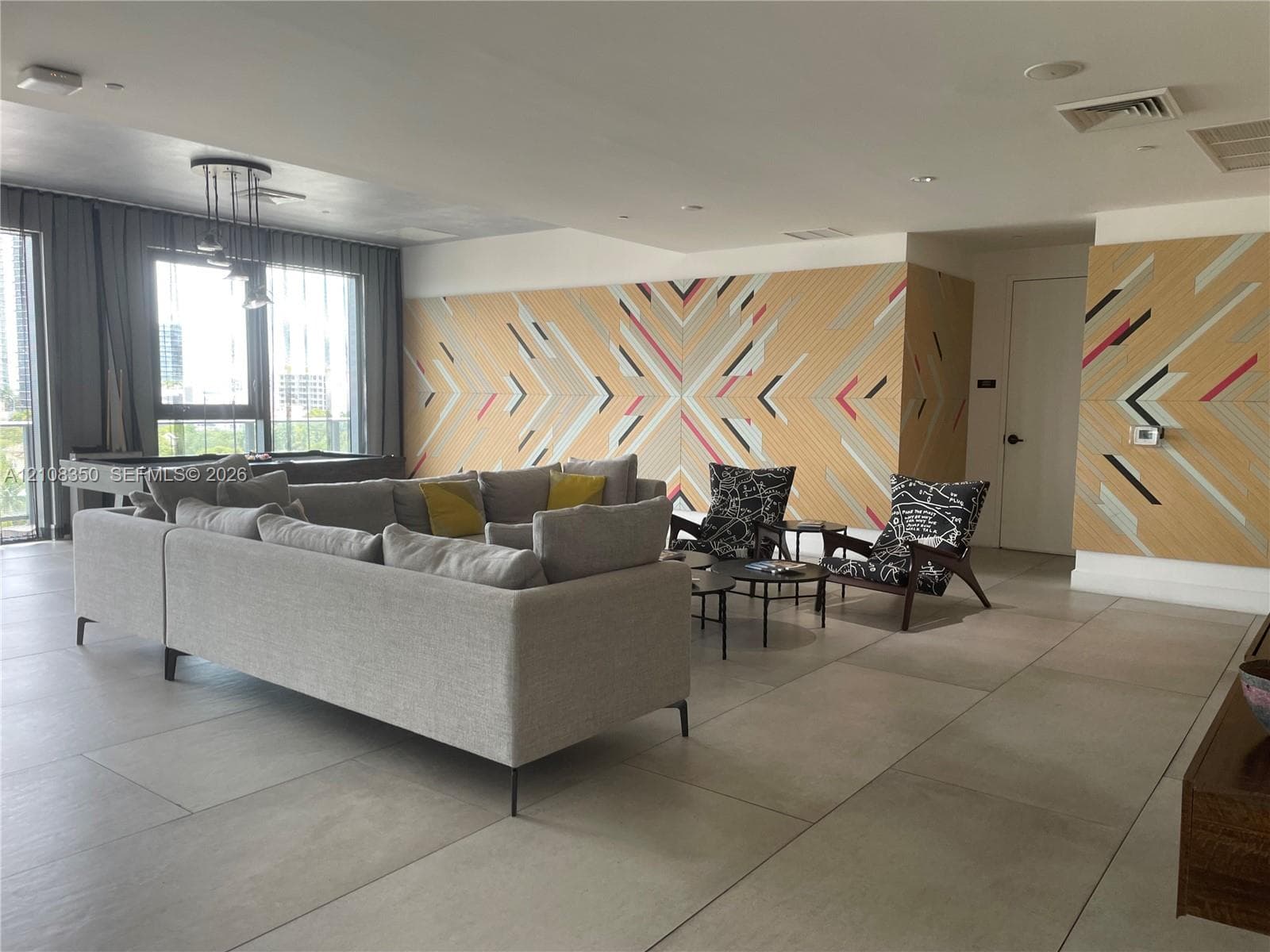 Large-format tile flooring, geometric wall paneling, and recessed ceiling lighting