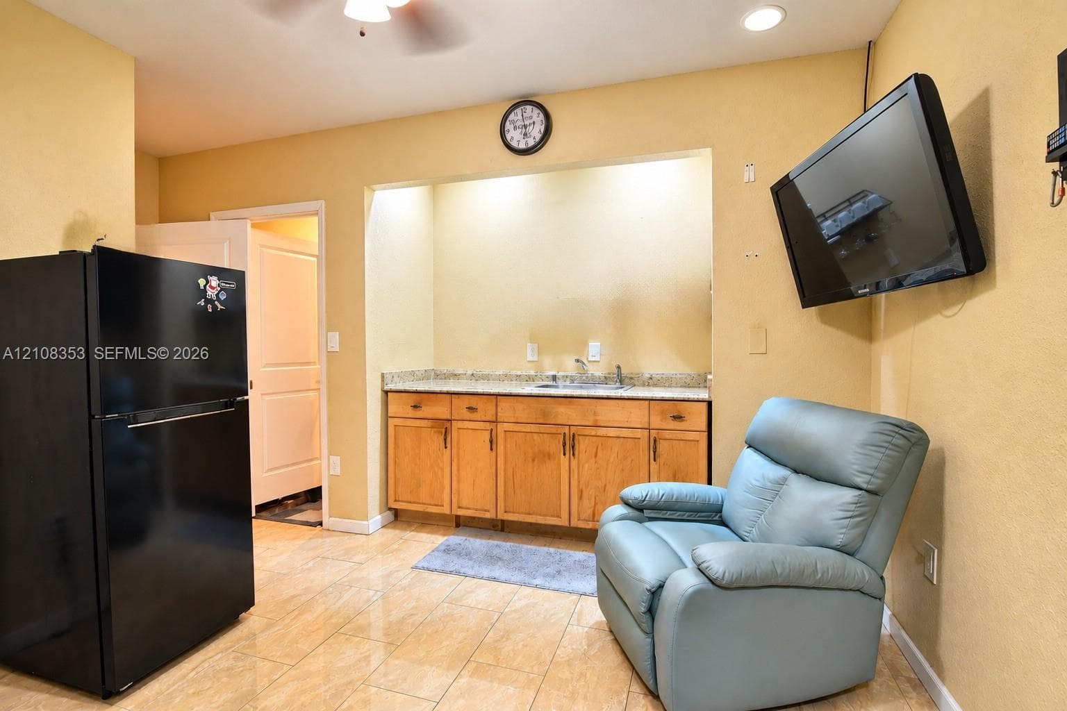 Built-in cabinetry with stone-finish countertops, stainless steel sink basin, tile flooring, and recessed ceiling lighting