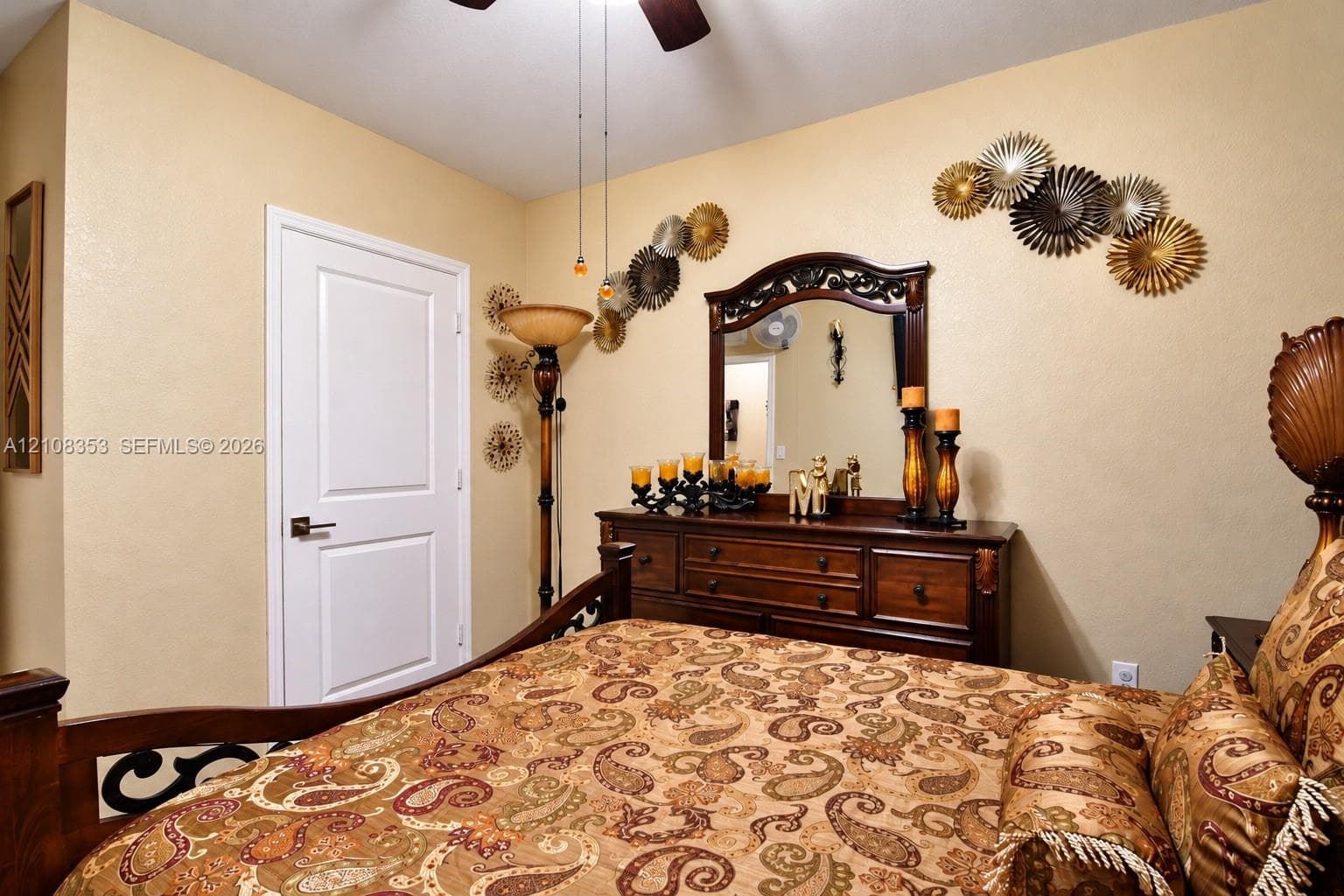 Room featuring a two-panel interior door with brushed metallic hardware and a ceiling-mounted light fixture with a fan