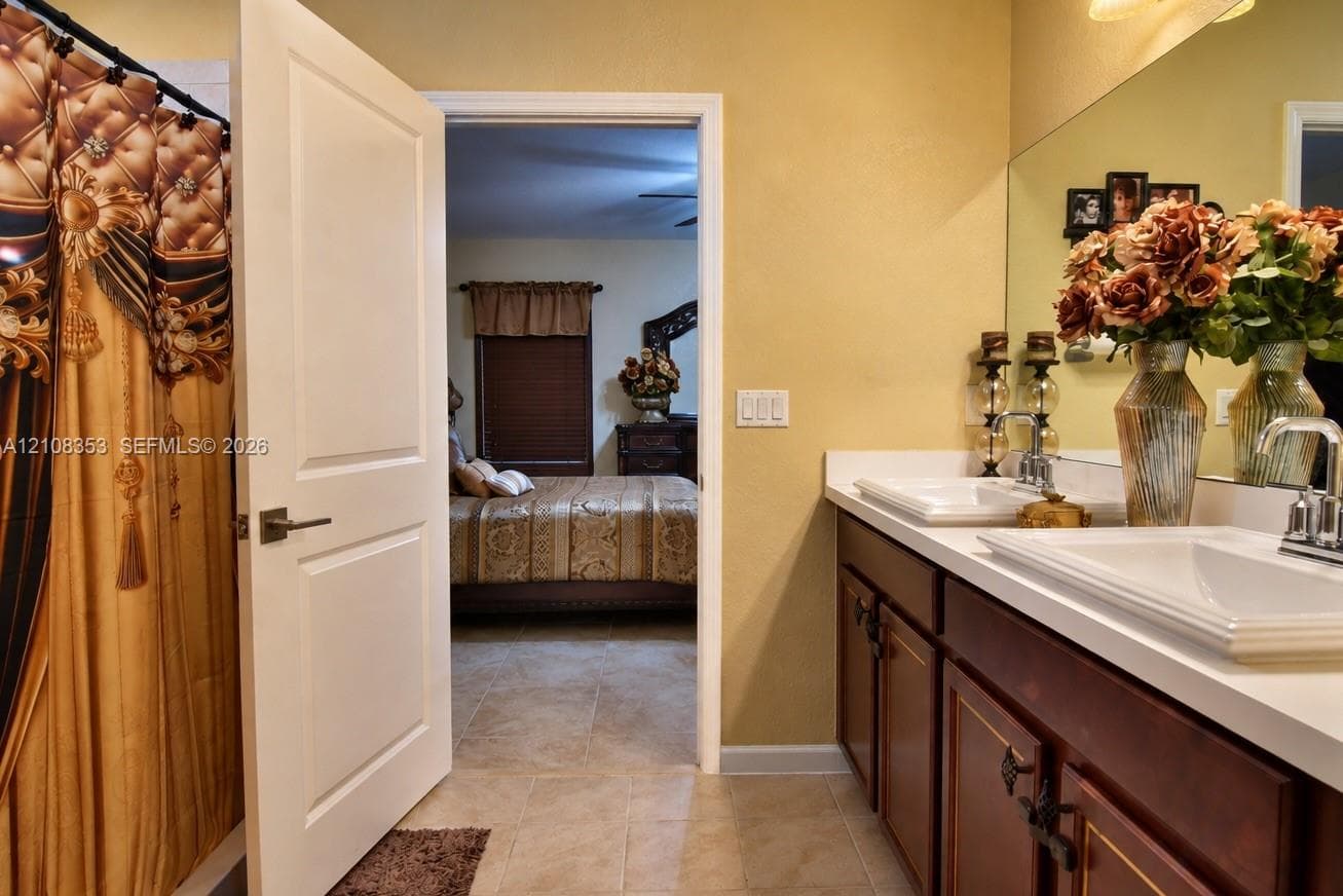 Dual-sink vanity with rectangular vessel sinks, white countertop, dark wood cabinetry, and large-format wall mirror