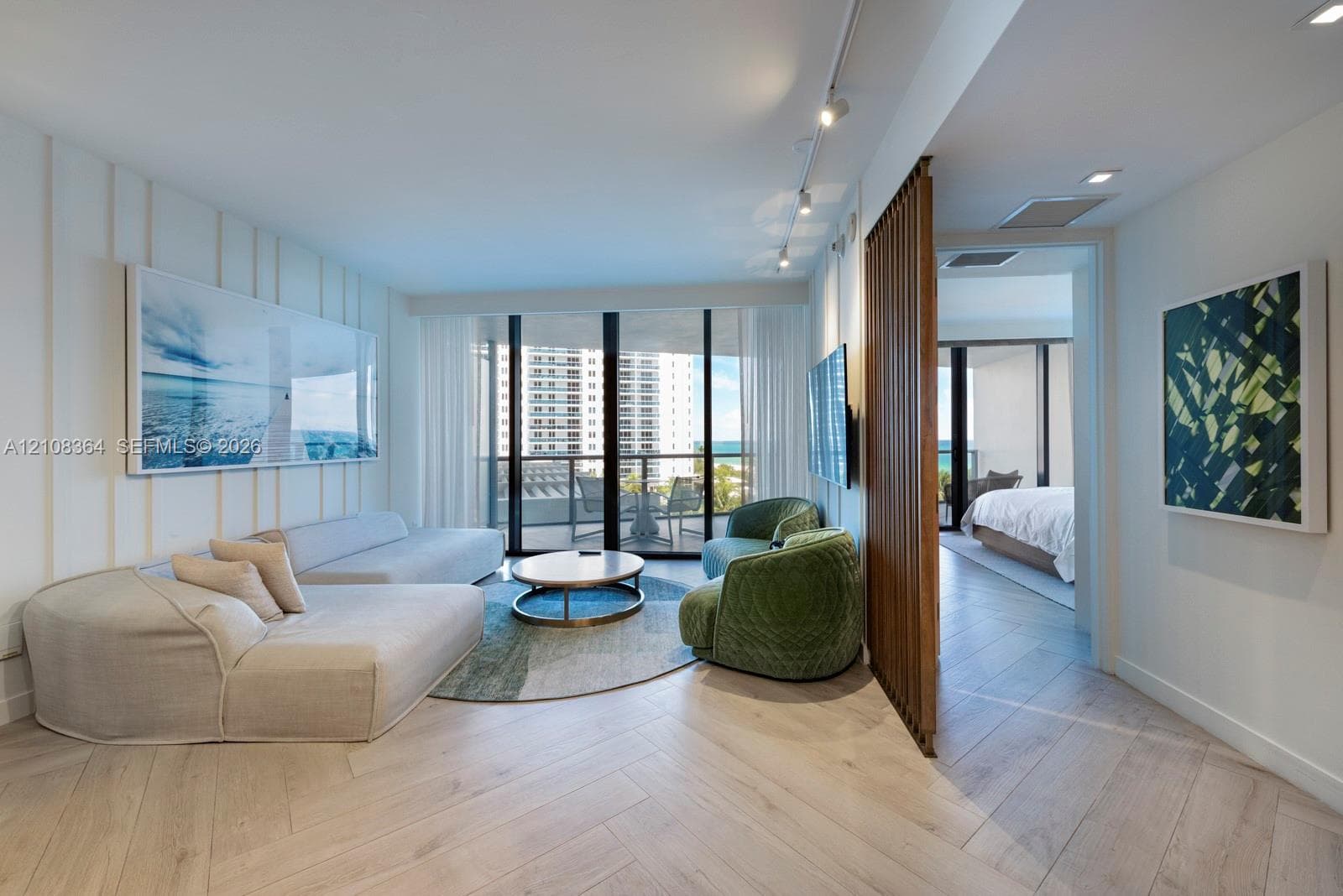 Herringbone-patterned wood-finish flooring, floor-to-ceiling glass doors, decorative vertical slat room divider, recessed track lighting, and board-and-batten wall detailing