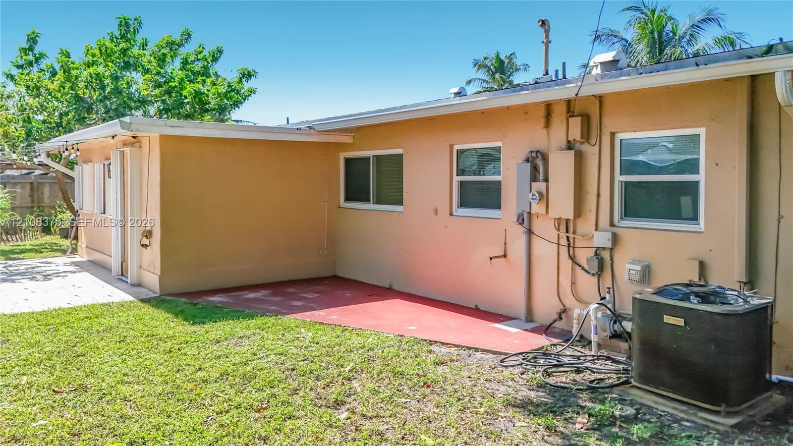 Exterior view featuring a concrete patio, horizontal sliding windows, and a dedicated central air conditioning unit