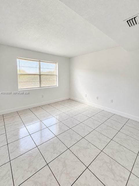 Neutral-toned interior space featuring glossy, square-format ceramic tile flooring, expansive smooth-finish white walls, and a large, multi-pane window with integrated blinds