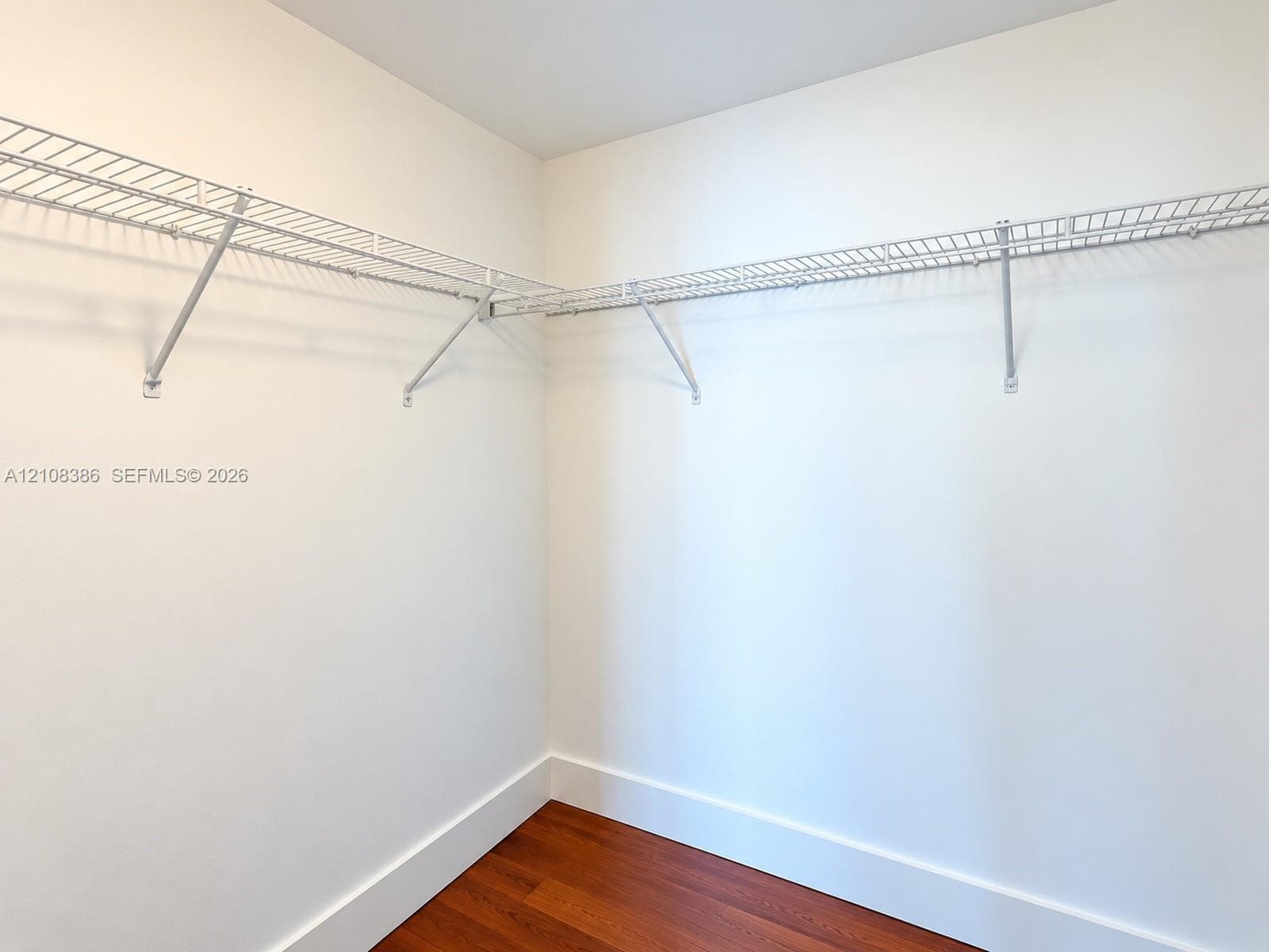 Walk-in closet featuring wood-finish flooring and white wire shelving