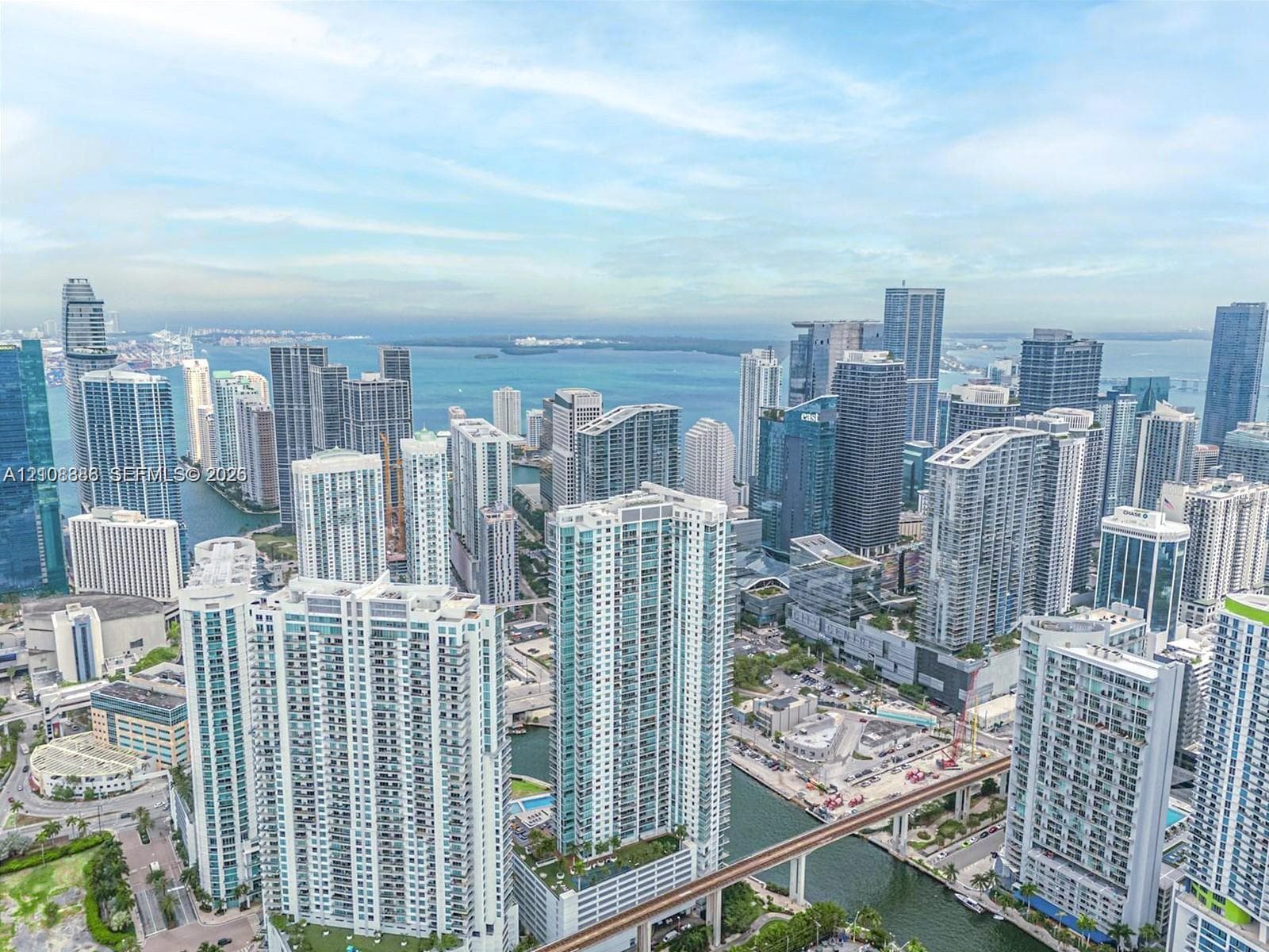 Aerial perspective featuring an extensive urban skyline, high-rise architectural density, and prominent coastal waterfront